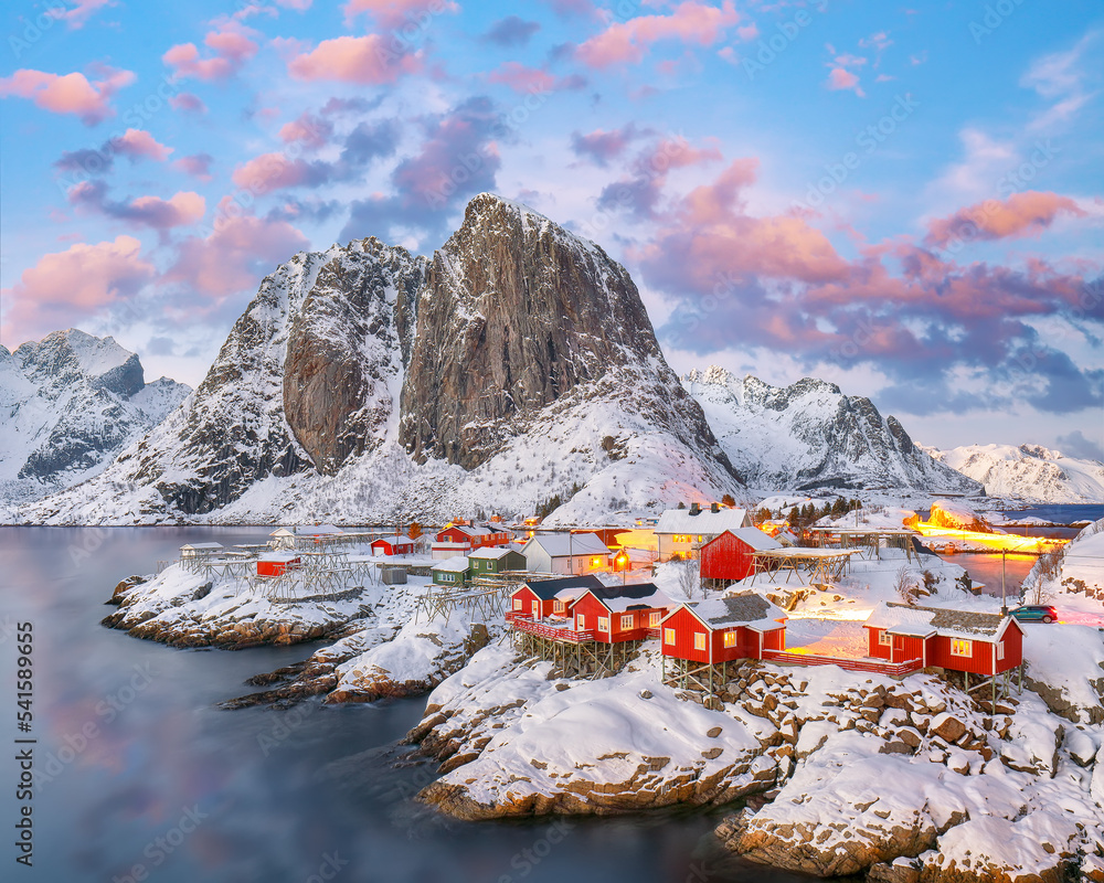 Amazing sunset winter view on Hamnoy village and Festhaeltinden mountain on background.