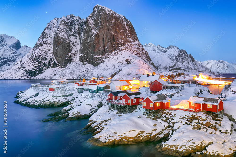 Outstanding sunset winter view on Hamnoy village and Festhaeltinden mountain on background.
