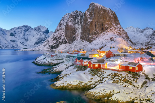Outstanding sunset winter view on Hamnoy village and Festhaeltinden mountain on background.