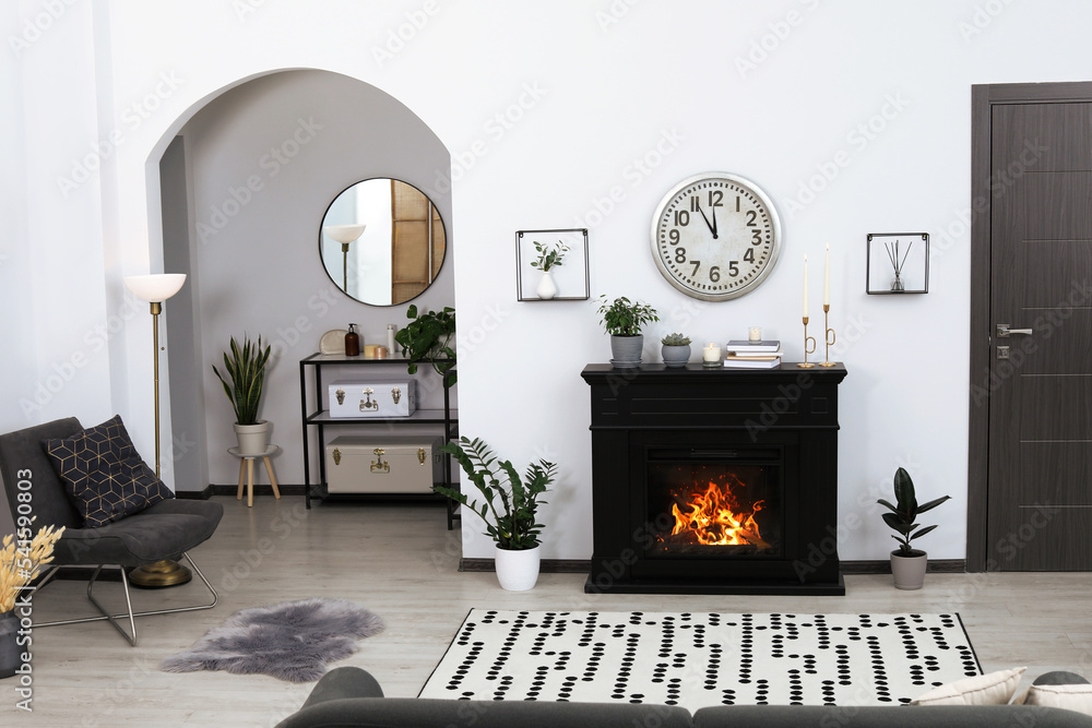 Fototapeta premium Stylish living room interior with fireplace and green plants