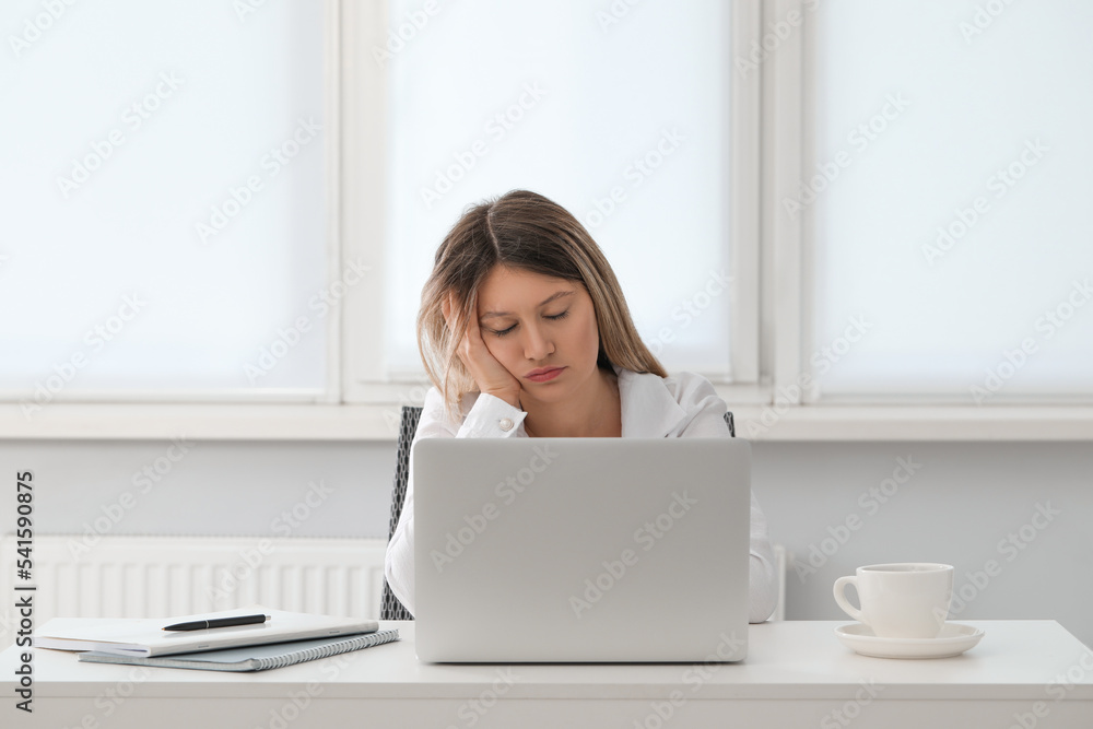 Tired young woman sleeping at workplace in office Tired young woman sleeping at workplace in office