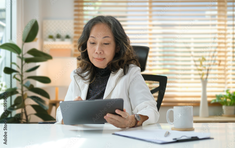 Happy senior woman surfing internet, checking email on digital tablet.. Happy senior woman surfing internet, checking email on digital tablet..