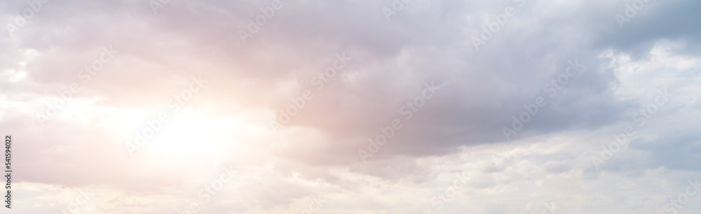 Panorama of golden cloudy sky with sun rays and heavenly back light