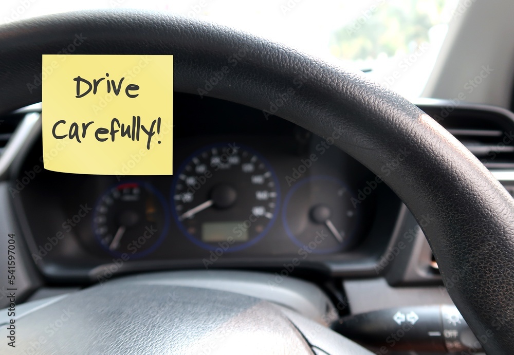 Car console panel with handwritten stick note DRIVE CAREFULLY , concept of car driver self reminder to to drive carefully with mindset of safety first, be alert to reduce accidents on the road