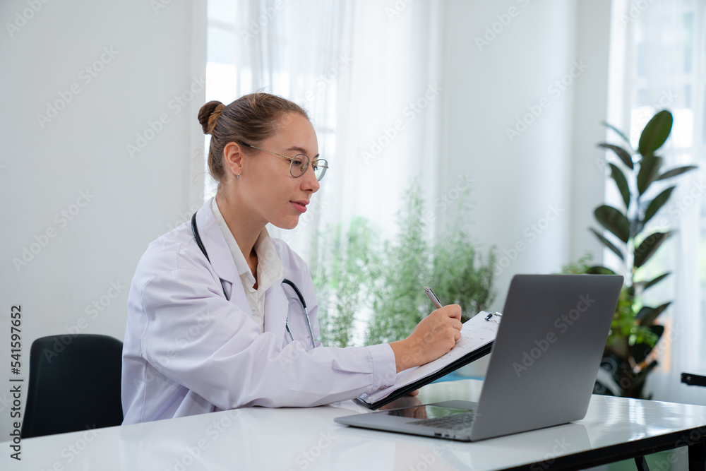 Woman doctor in uniform greeting patients online on laptop during on line meeting. Woman doctor in uniform greeting patients online on laptop during on line meeting.