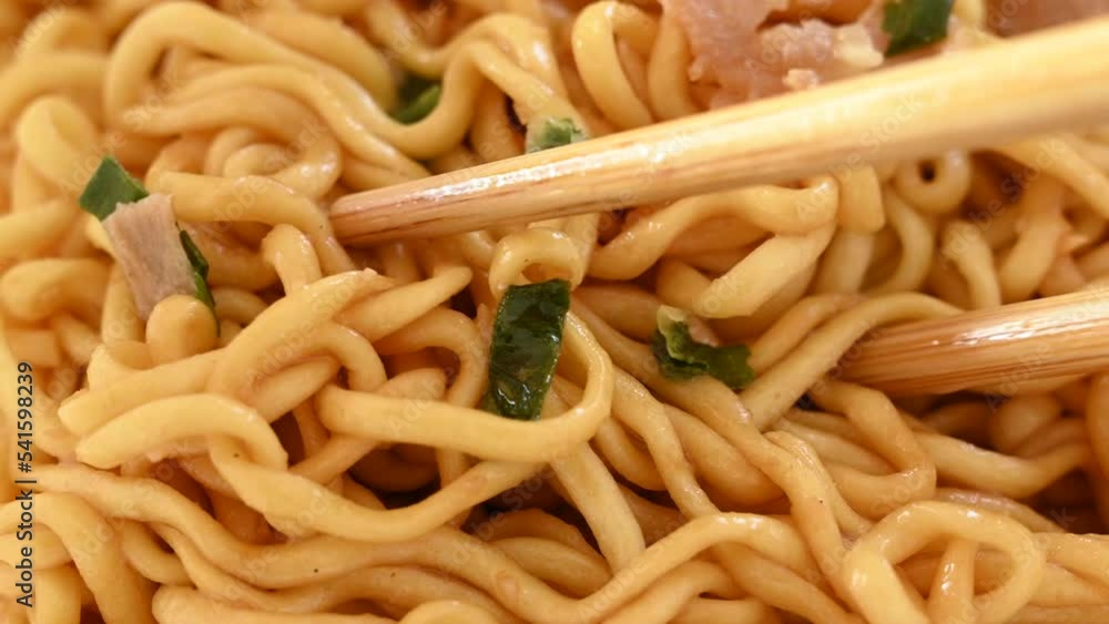 Lifting up instant Aburasoba noodles with shopsticks Lifting up instant Aburasoba noodles with shopsticks