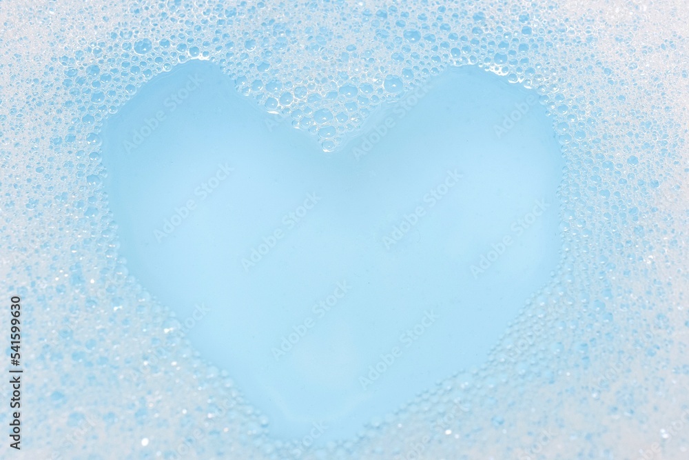 white soap bubbles floating heart shaped blue background love concept