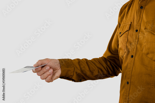 Male tourist's hand holding boarding pass during registration for departure, studio, light gray background