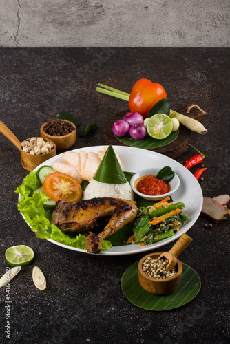 Ayam Bakar or Roasted Chicken with herb and spice from Indonesia, served on white Oval plate 