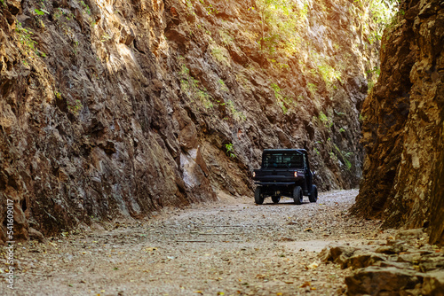 Tourist SUV car cruising along a rugged route through the gorge that was once a former railway line built by prisoners of war during the World War 2 at Hellfire Pass in Kanchanaburi Province,Thailand. photo