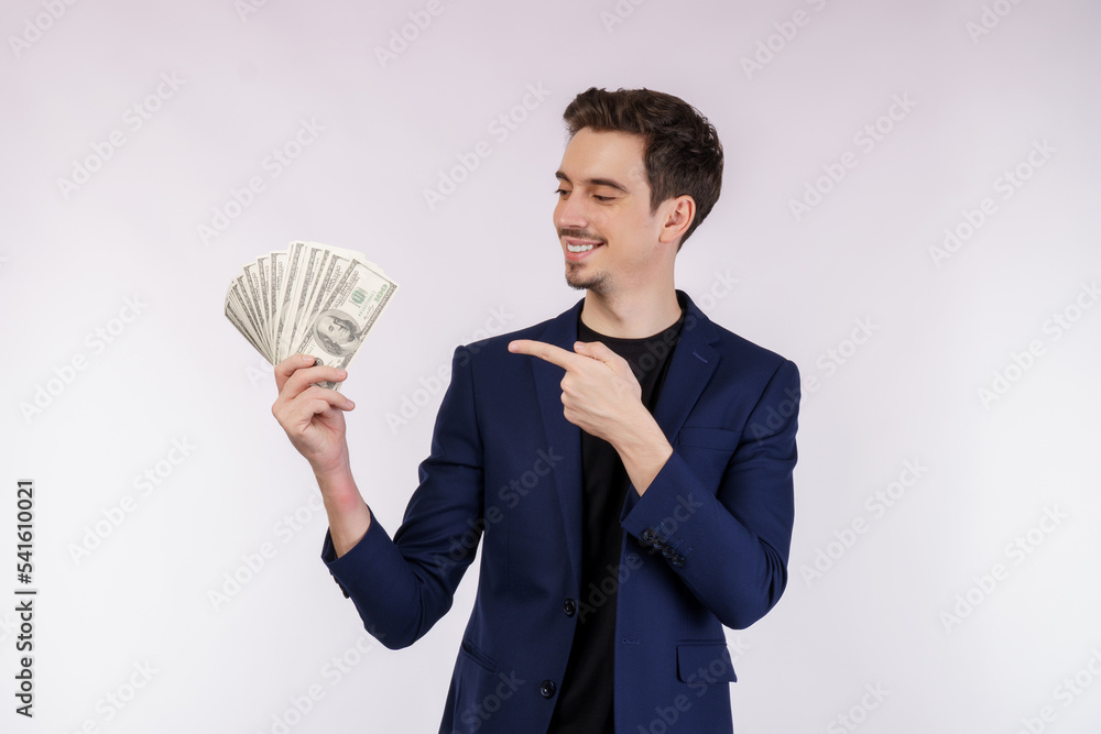 Portrait of a cheerful man pointing finger at bunch of money banknotes over white background Portrait of a cheerful man pointing finger at bunch of money banknotes over white background