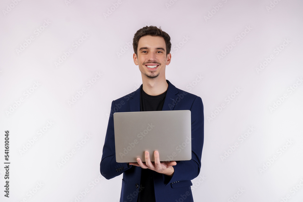 Portrait of young handsome smiling businessman holding laptop in hands, typing and browsing web pages isolated on white background
