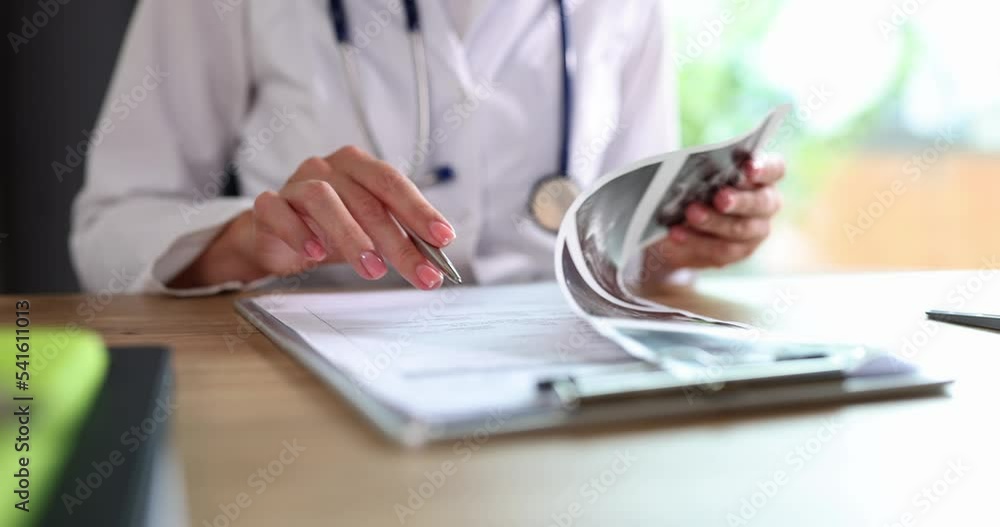 Hands of gynecologist doctor holding and examining an ultrasound scan of uterus Hands of gynecologist doctor holding and examining an ultrasound scan of uterus