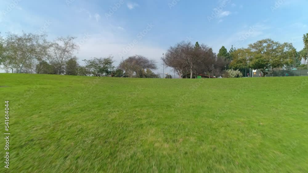 Aerial: Disc Golf Basket By Sports Court In City, Drone Flying Backwards Over Green Landscape - Los Angeles, California Aerial: Disc Golf Basket By Sports Court In City, Drone Flying Backwards Over Green Landscape - Los Angeles, California