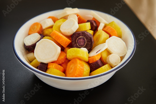 Carrots of three colors sliced into slices in bowl are ready for cooking
