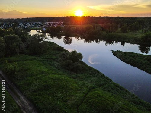 Landscape with a railway bridge over the Klyazma river on the background of sunset. photo
