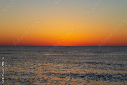 Beautiful sky with dark orange color after sunset over the sea. Georgia. Kobuleti