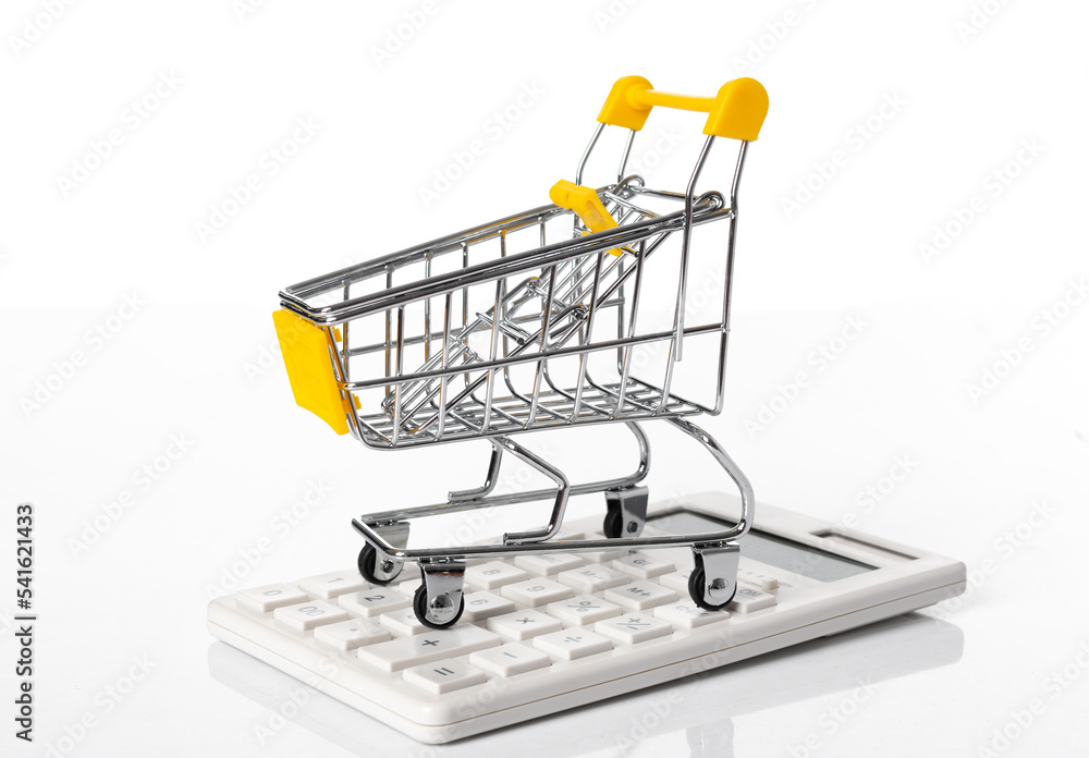 Empty yellow shopping cart parking on the calculator- business and finance- concept- isolated on white background