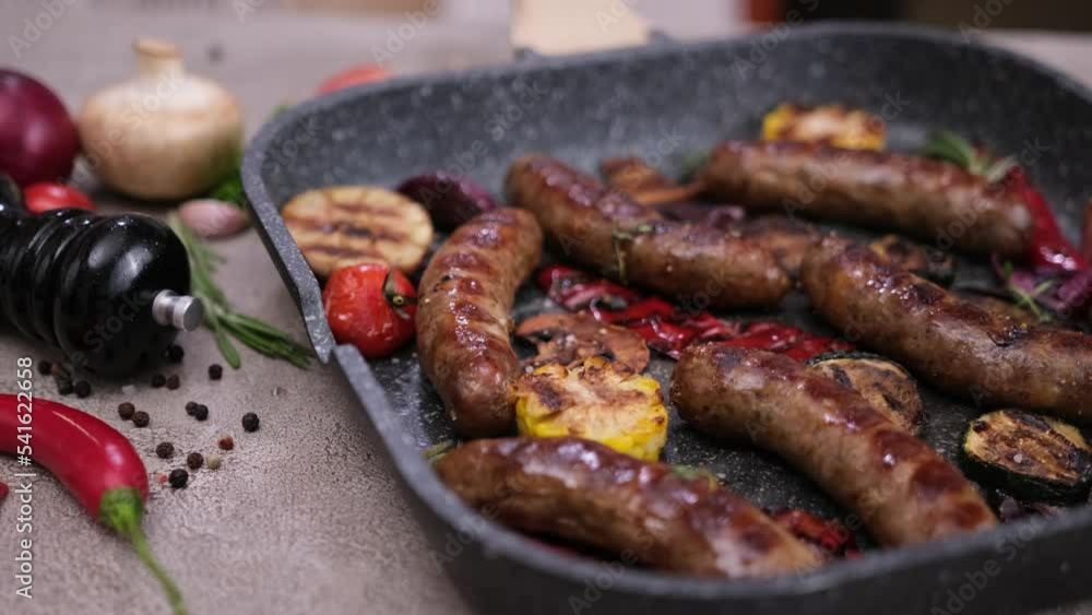 Homemade juicy pork sausages with spices and vegetables frying on grill frying pan Homemade juicy pork sausages with spices and vegetables frying on grill frying pan