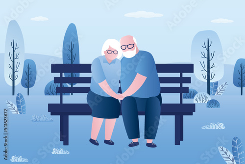 Loving couple of old people is sitting on bench in public park. Summer time, grandparents are resting in nature. Elderly people hugging and sits on bench. Family relations, partnership.