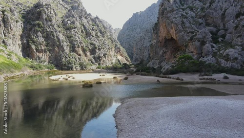 Scenic drone view of a valley at sa calobra Mallorca with water running beneath and mountains towering on the sides photo