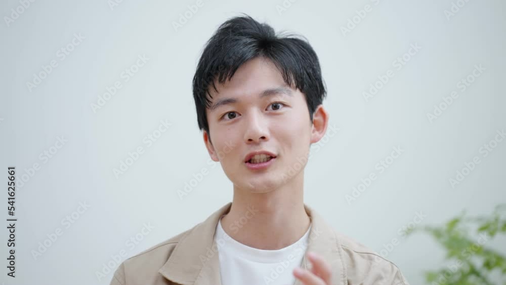 オンラインミーティングをする若い男性 オンラインミーティングをする若い男性
