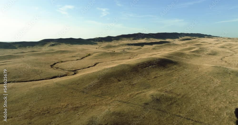 Arid hilly landscapes with skin peak mountain. Aerial drone view at summer sunny day Arid hilly landscapes with skin peak mountain. Aerial drone view at summer sunny day