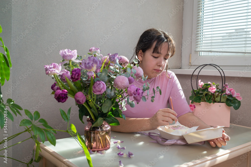 Happy teen girl unpacks her present. Birthday party and wishes concept. Happy teen girl unpacks her present. Birthday party and wishes concept.