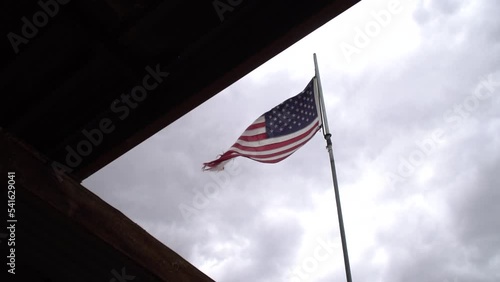 Worn and torn flag. American flag in a stiff breeze, flapping and tattered because of exposure