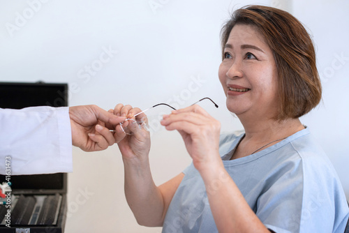 Optometrist has an elderly woman try out new glasses  Asian elderly woman smiled and looked at him  eyesight and vision concept