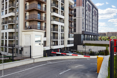 Road to buildings parking. Automatic barrier, entrance to the parking lot