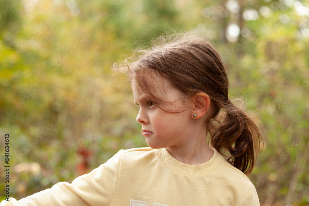Little blonde girl in a yellow sweatshirt on a walk in autumn Little blonde girl in a yellow sweatshirt on a walk in autumn