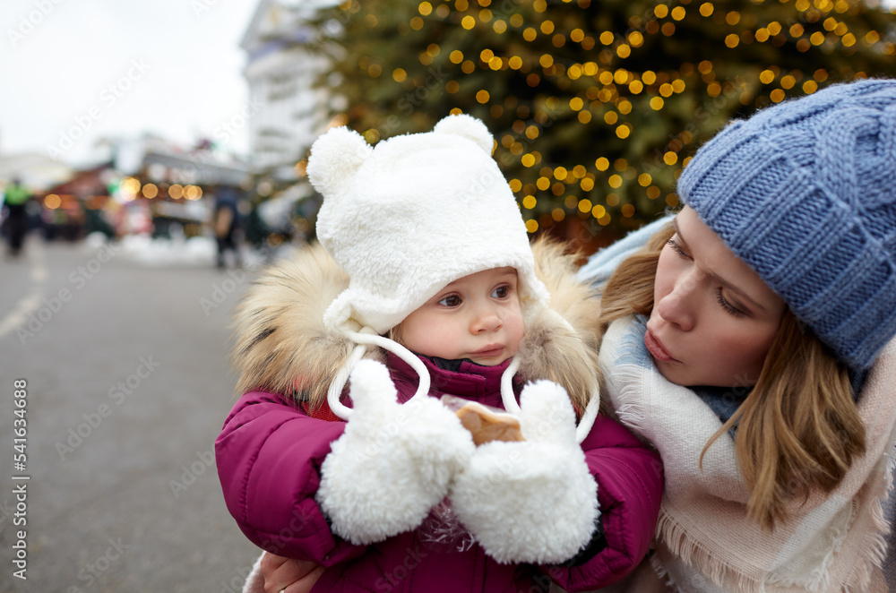 Mother and daughter are walking around the city on Christmas and New Year holidays. Portrait of happy mother and daughter having fun in the street Mother and daughter are walking around the city on Christmas and New Year holidays. Portrait of happy mother and daughter having fun in the street