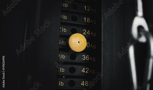 Stack of metal plates with yellow pin in a weight training equipment machine. Bodybuilding workout.
