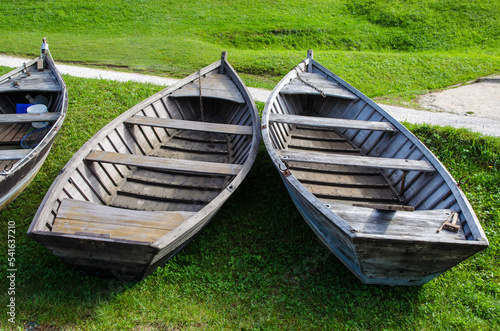 Barche per il turismo distese sulla riva erbosa del lago di Santa Croce in Alpago in una giornata di sole photo