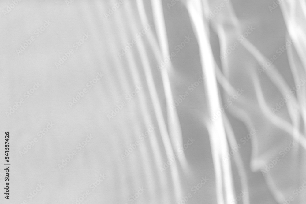 Obraz premium Blurred defocused water texture overlay effect for photo and mockups. Organic drop diagonal shadow and light caustic effect on a white wall. Shadows for natural light effects