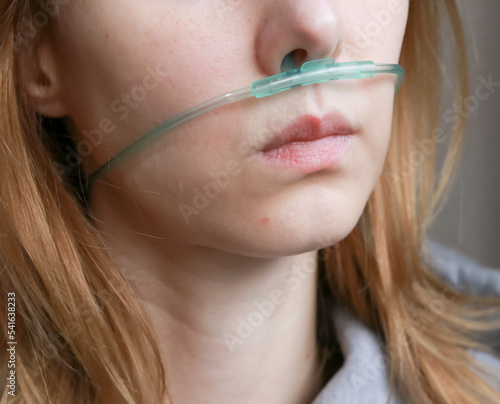Caucasian woman with blond hair that has the tube of an oxygen concentrator attached to her nose  photo
