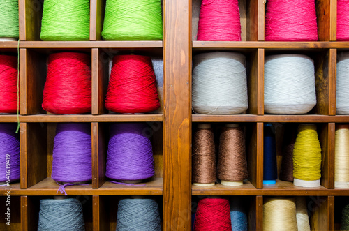 I rocchetti di filo di vari colori sistemati in un mobile all'interno di una industria tessile photo