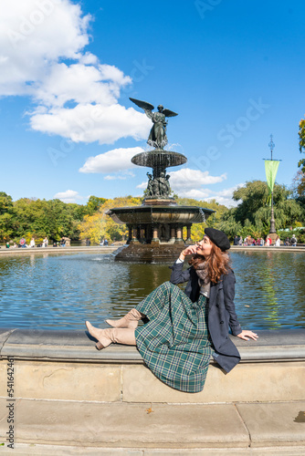 Tourist girls sit at the fountain at Central Park  New York City at Belvedere Castle during an autumn.