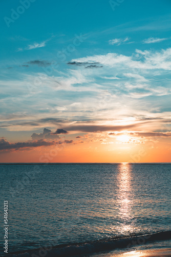 Fototapeta Naklejka Na Ścianę i Meble -  Scenic sunset in the Playa de la Cueva Beach, Cabo Rojo, Pedernales, Dominican Republic. Vibrant colors, sun above water falling in the sea. Romantic vacation atmosphere.