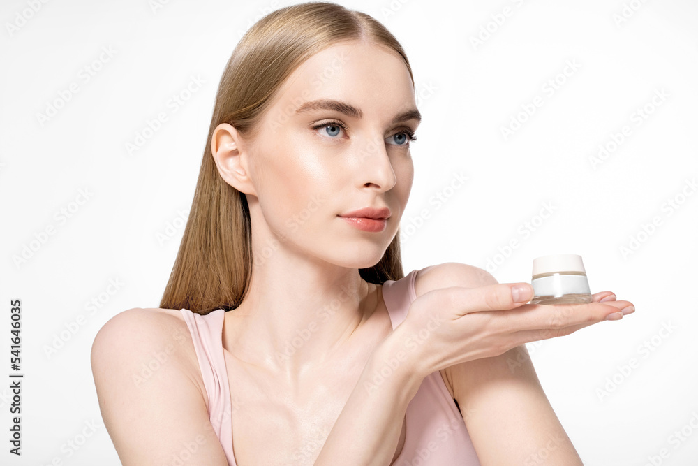Girl model with natural makeup is holding a cosmetic jar of skin moisturizer on white background Girl model with natural makeup is holding a cosmetic jar of skin moisturizer on white background