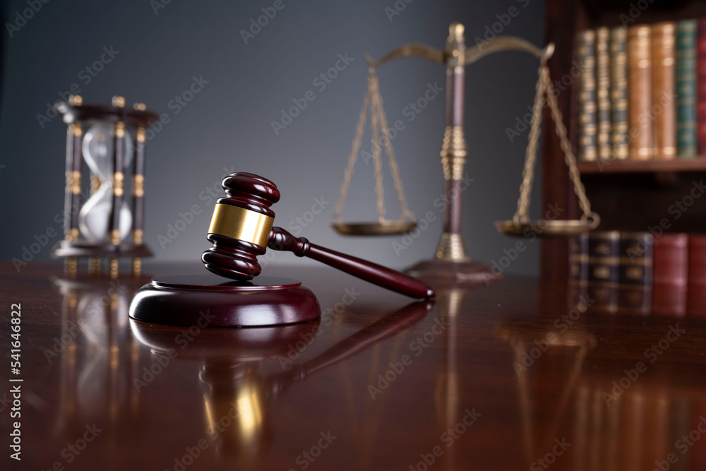 Lawyer office. Judge’s gavel, scale, Themis sculpture and legal books in the bookshelf. Lawyer office. Judge’s gavel, scale, Themis sculpture and legal books in the bookshelf.