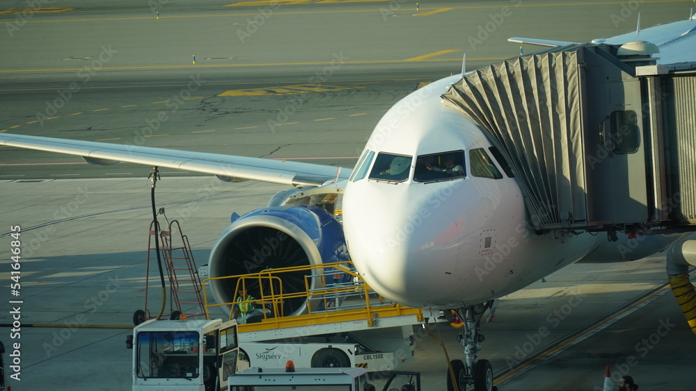 Cyprus, Larnaca - October 12, 2022:The plane is at the pull-out arm at the airport. Preparing a flight: airplane with passenger boarding bridge attached Cyprus, Larnaca - October 12, 2022:The plane is at the pull-out arm at the airport. Preparing a flight: airplane with passenger boarding bridge attached