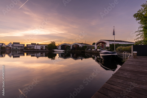 Ferienhäuser und Boote bei Dämmerung am Kanal in Lemmer Holland