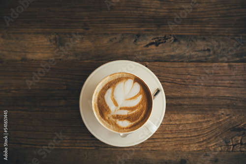 Foto White cup with fresh cappuccino on wooden background