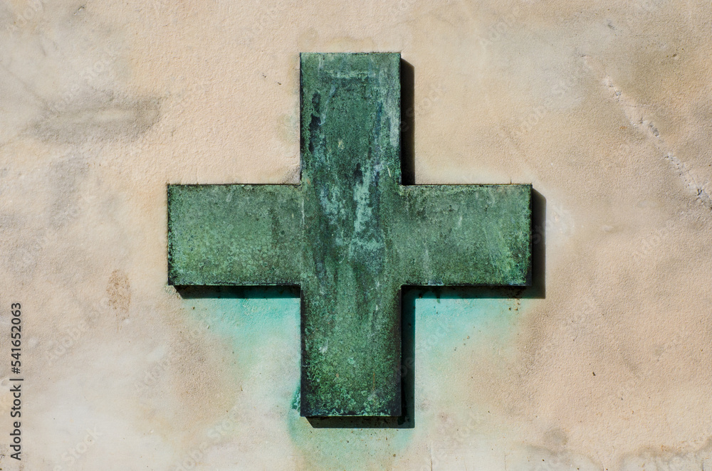 Una croce di bronzo verde di ossidazione su una tomba del cimitero di San Michele a Venezia