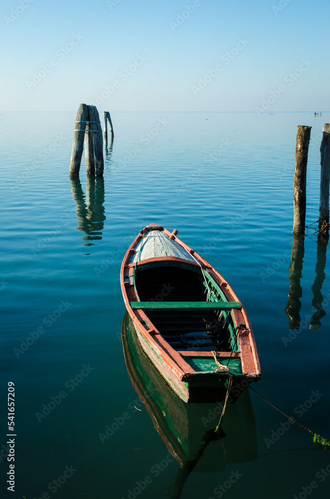 Una piccola barca di legno ormeggiata a Pellestrina, isola della laguna di Venezia, in una giornata invernale 