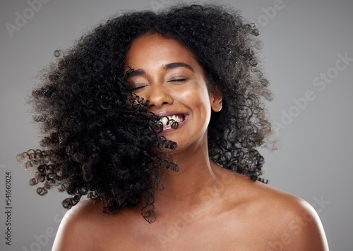 Black woman, hair and beauty, hair care or curly hair on gray studio background. Smile, skincare and young beautiful female model from Nigeria with healthy curls after luxury salon treatment. photo