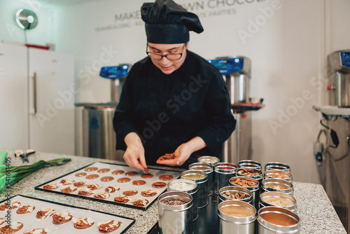 real female master chef chocolatier working in artisanal professional chocolate laboratory photo