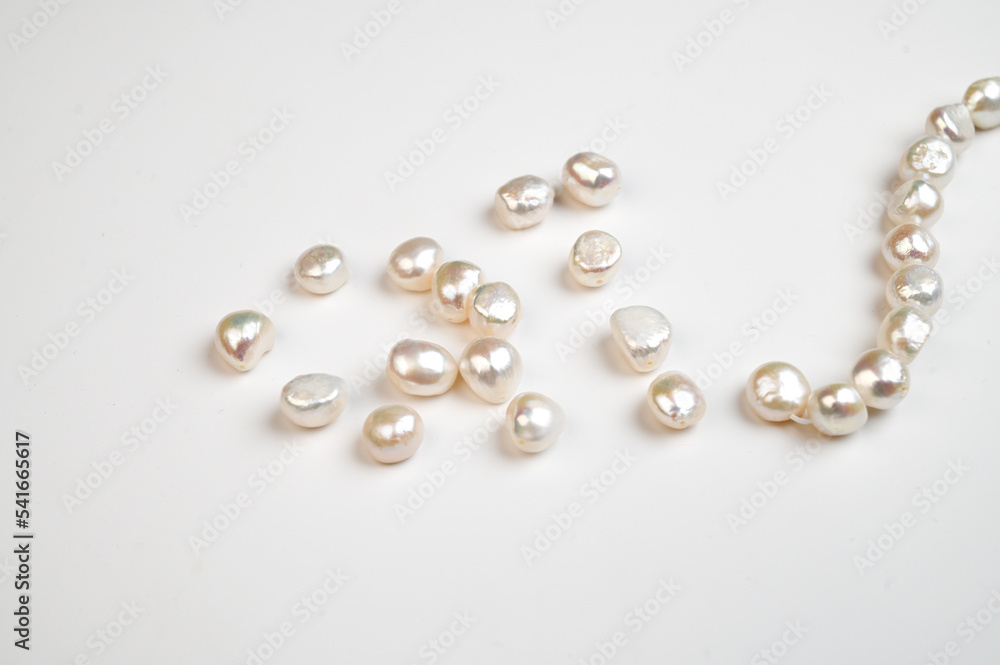 Natural freshwater round pearl beads on white background. Top view Natural freshwater round pearl beads on white background. Top view